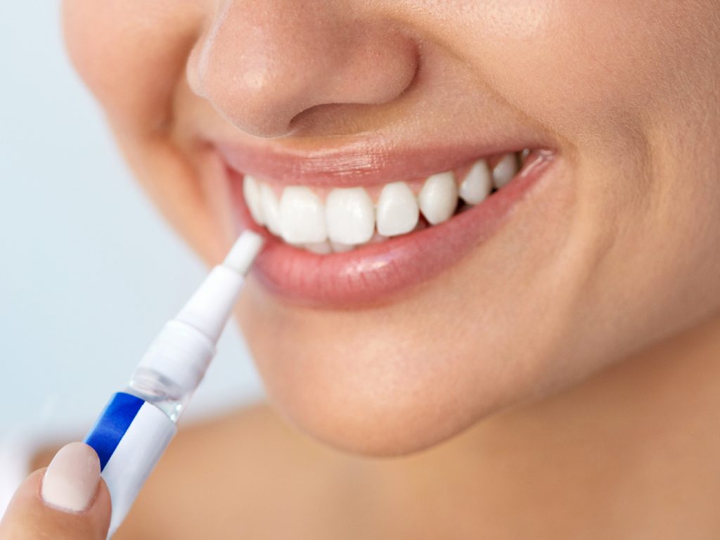 Girl using teeth whitening pen