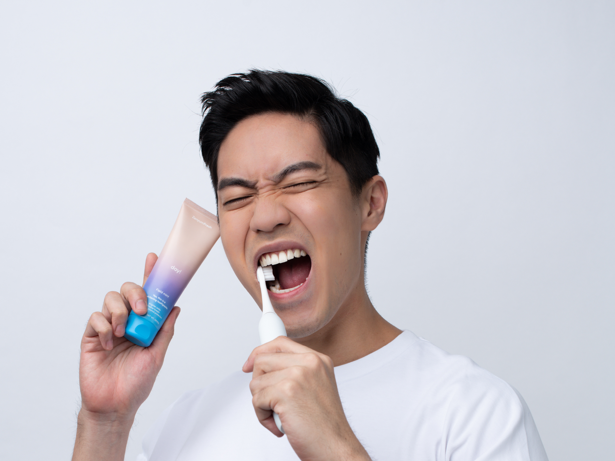 Man brushing his teeth with ZenyumSonic Toothbrush