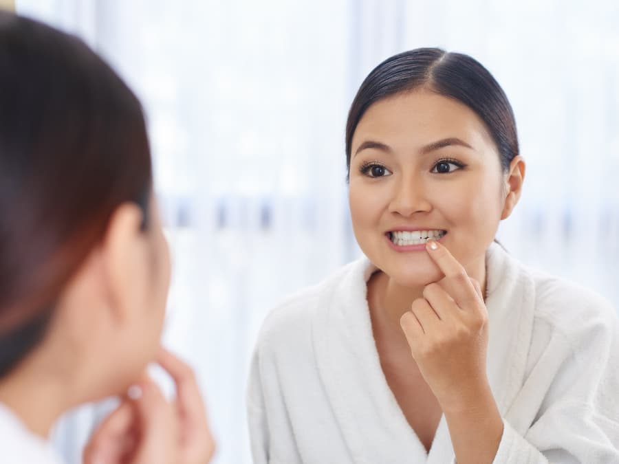 Woman checking her teeth in the mirror