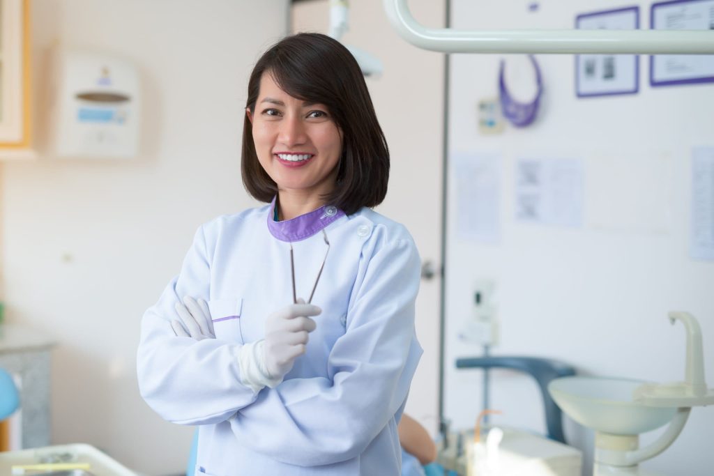 Asian woman dentist holding a dental tool