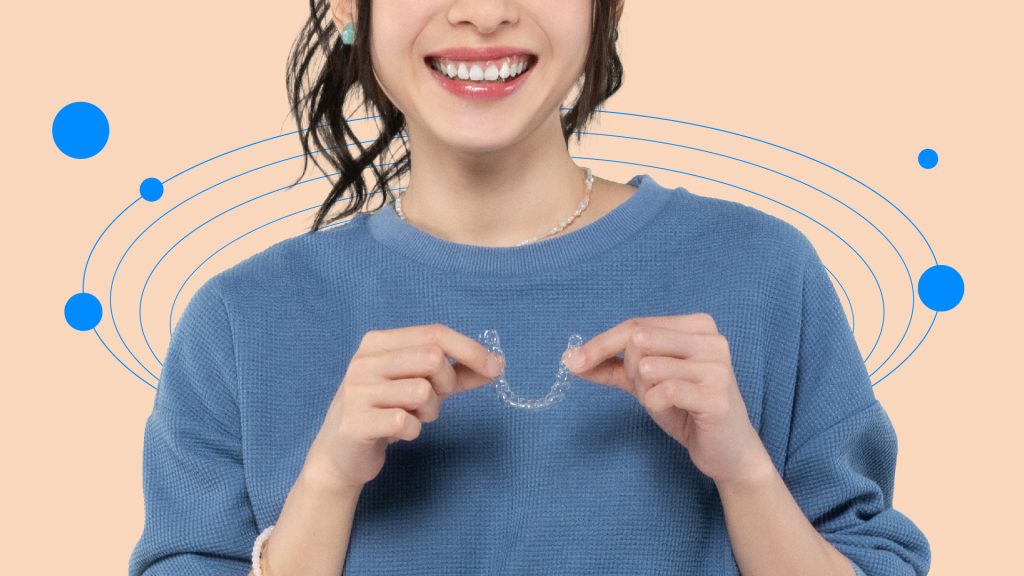 Girl holding a clear aligner smiling