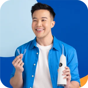 A guy in blue shirt smiling with Zenyum Water Flosser