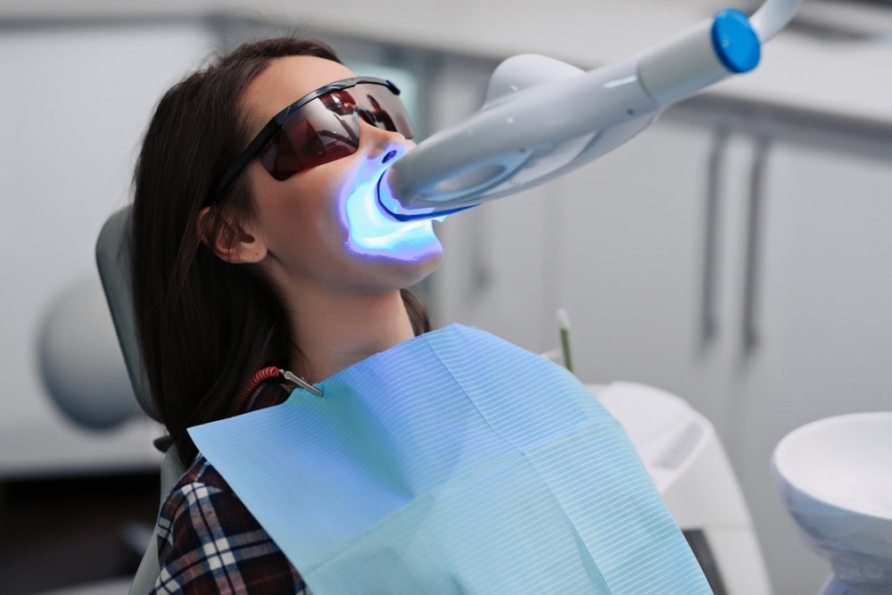 一名女士正使用藍光美白牙齒機