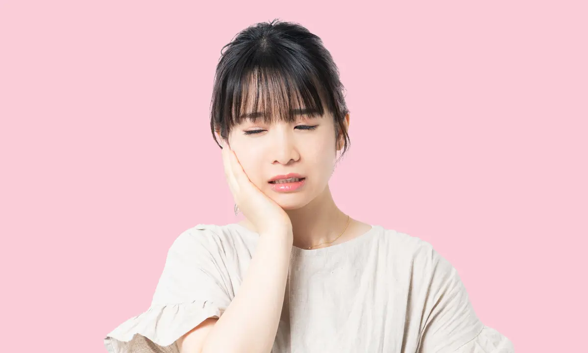 How to stop bruxism: Lady holding her jaw while grinding her teeth